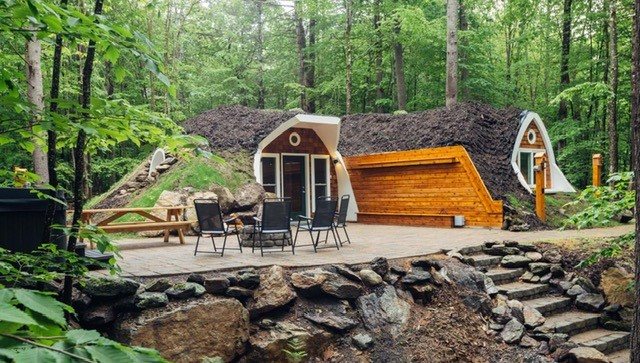 Finished paver patio with stone steps and retaining wall in a wooded Maine setting